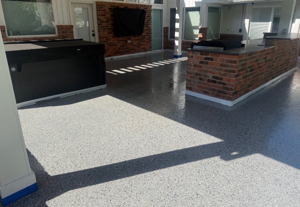 Gray flake epoxy patio floor with brick outdoor kitchen